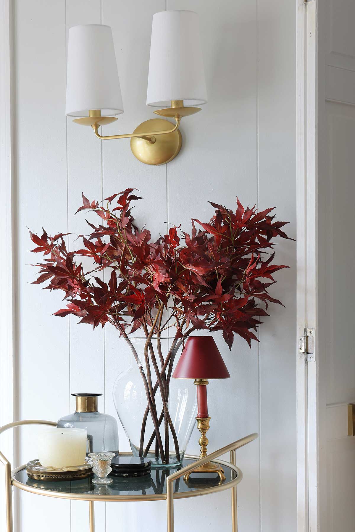 Faux red maple leaves. Branches in a glass vase.