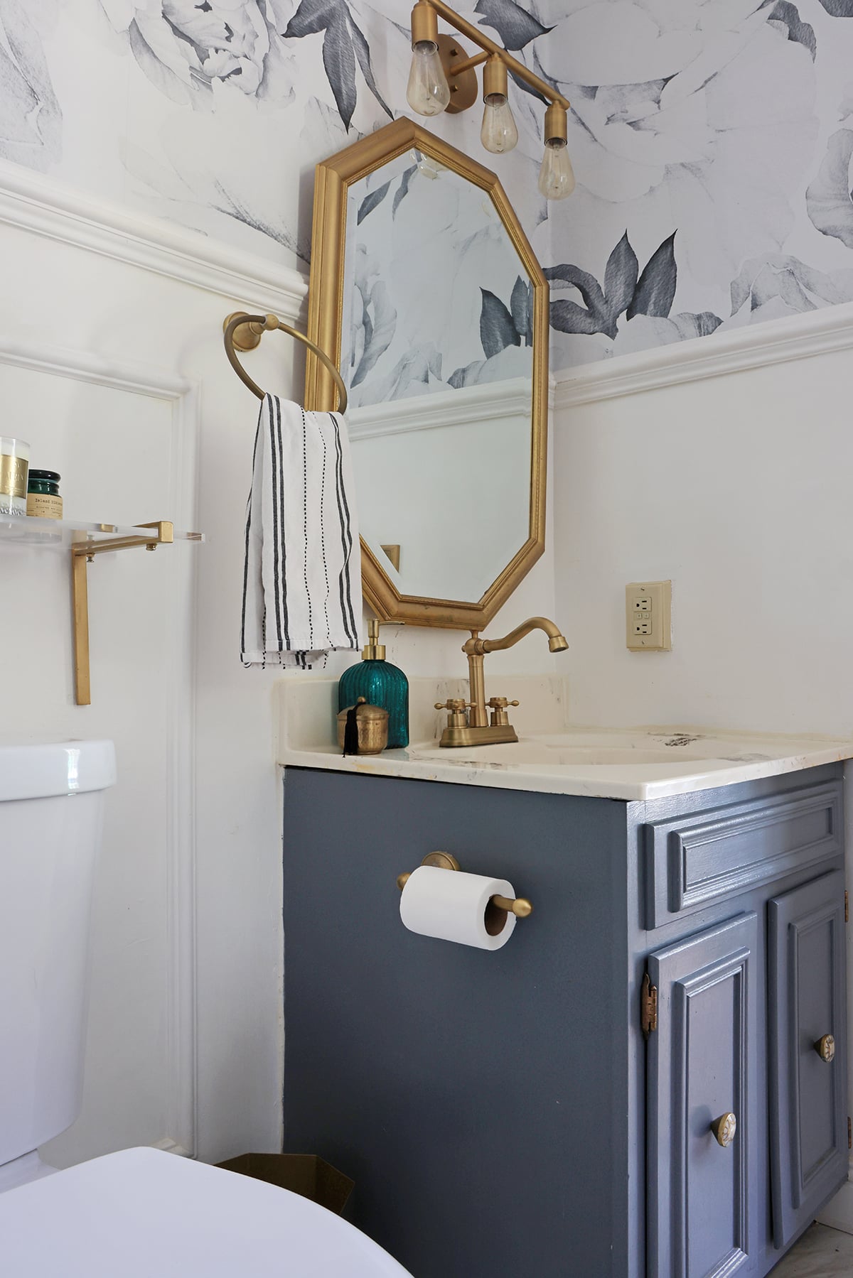 Powder room with blue vanity and gold fixtures