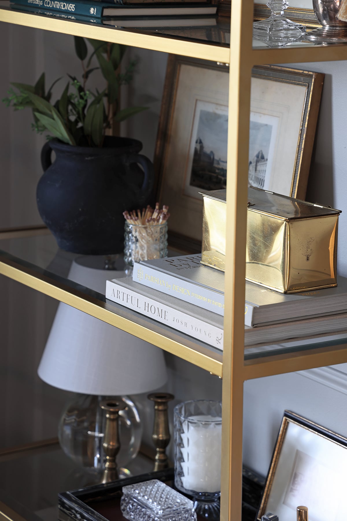Gold tin on a stack of books on a bookshelf