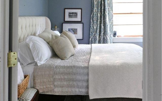 Guest bedroom with lots of plush pillows and spare blankets