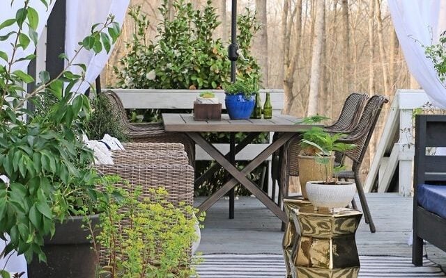 By mixing wooden furniture with metallic accessories, you can create a cozy but modern outdoor seating area like this.