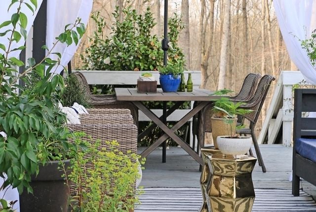 By mixing wooden furniture with metallic accessories, you can create a cozy but modern outdoor seating area like this.
